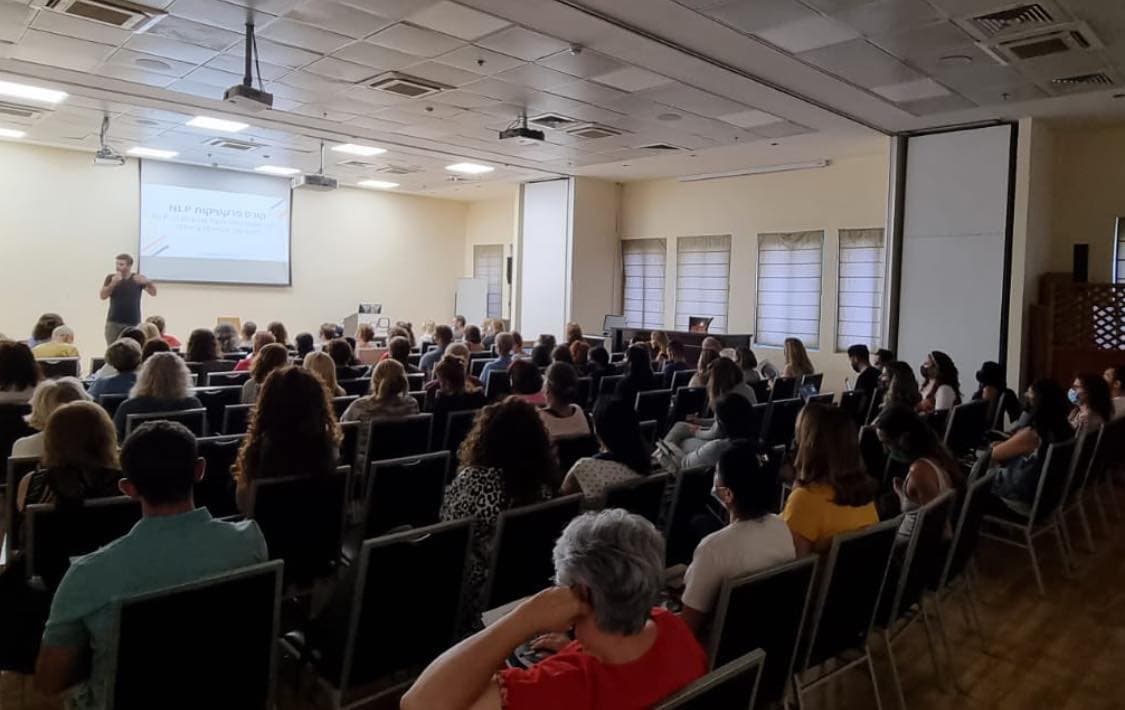 גל צחייק מעביר קורס פרקטישנר NLP באולם הרצאות מלא